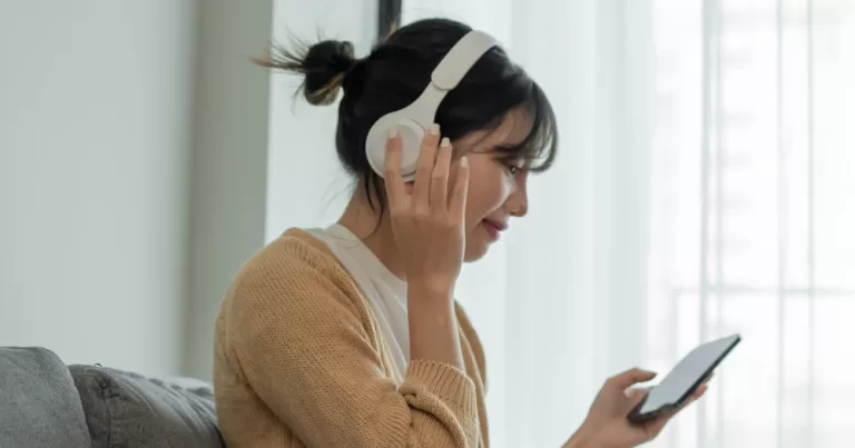 A person wearing headphones is listening to music. This article is in regard to creating a christmas playlist