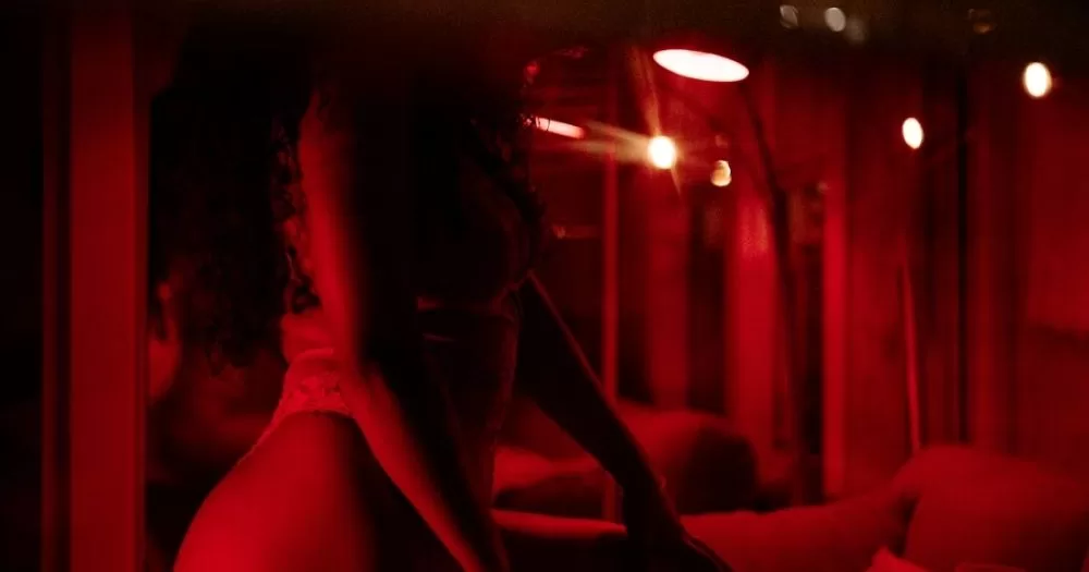 This article is about kinky sex parties in Russia. In the photo, a person wearing lingerie in a room with red lighting.