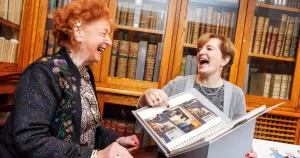 Katherine Zappone and Anne Louise Gilligan laughing together whilst holding their archival papers