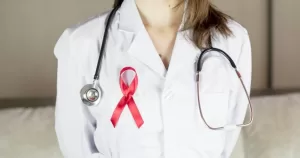 This article is about HIV cases among women in Ireland. In the photo, a doctor wearing a scrub and an AIDS ribbon.