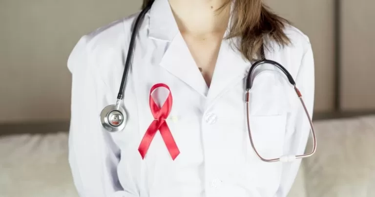 This article is about HIV cases among women in Ireland. In the photo, a doctor wearing a scrub and an AIDS ribbon.