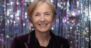 Paula Fagan smiling at the camera with a sparkly background at the GALAS.