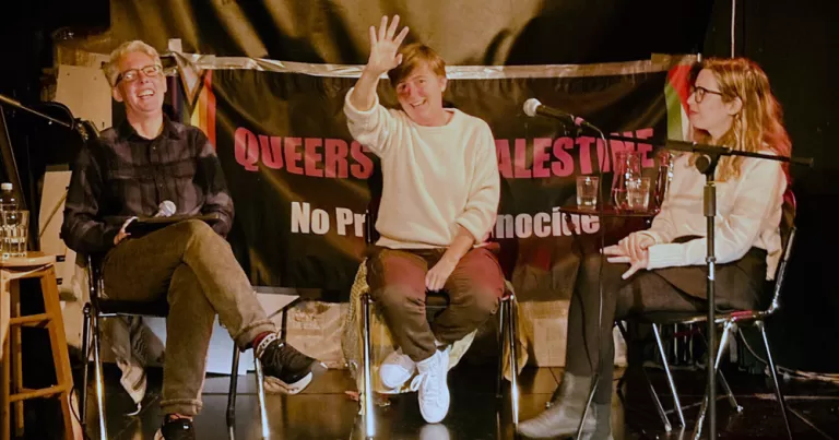 This article is about an event organised by Queers for Palestine with two participants in the Global Sumud Flotilla. in the photo, Irish writers Sarah Clancy and Naoise Dolan as they are interviewed by social justice activist Lydia Bigley on a stage.