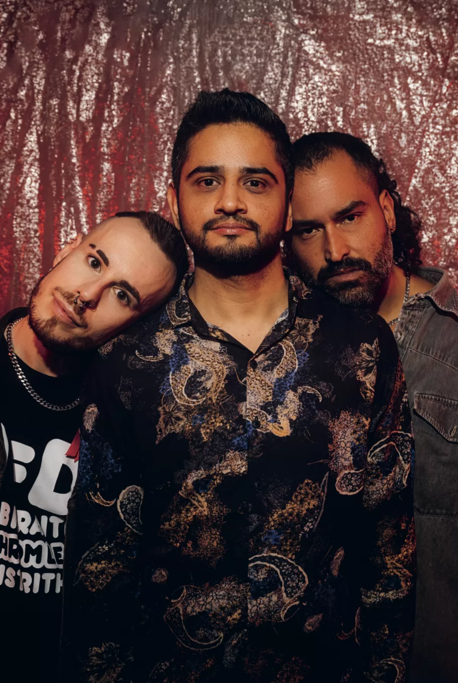 Jordi, Prateek and Luis from Out Of Shadows lean in to one another. They are the actors of Out of Shadow, a film about queer migrants living with HIV.