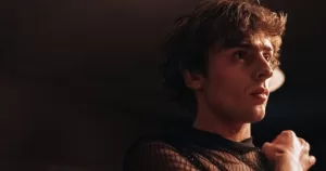 A young man looks to the side in a still from His House, Home, a queer Irish film.