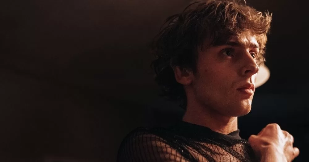 A young man looks to the side in a still from His House, Home, a queer Irish film.