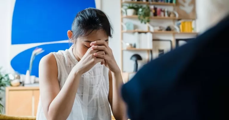 A person holds their head in their hands.
