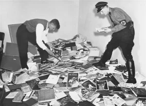 German students and a Nazi SA in the library of Dr. Magnus Hirschfeld, Director of the Institute for Sexual Research in Berlin. Rare books on the topics of sex and gender were loaded onto trucks and carted away for burning.