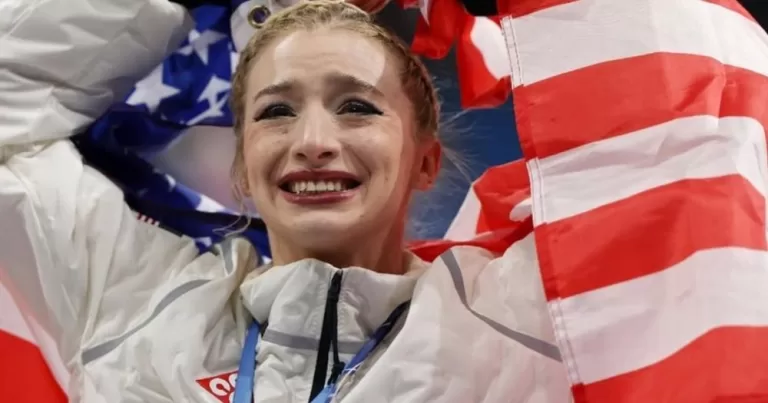 Amber Glenn holds the US flag in victory.