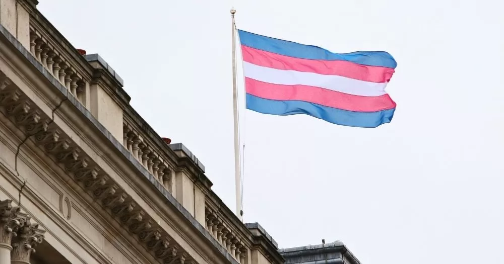 This article is about a formal complaint against Hilary Cass following her interview with the BBC. In the photo, a trans flag flying on a building.