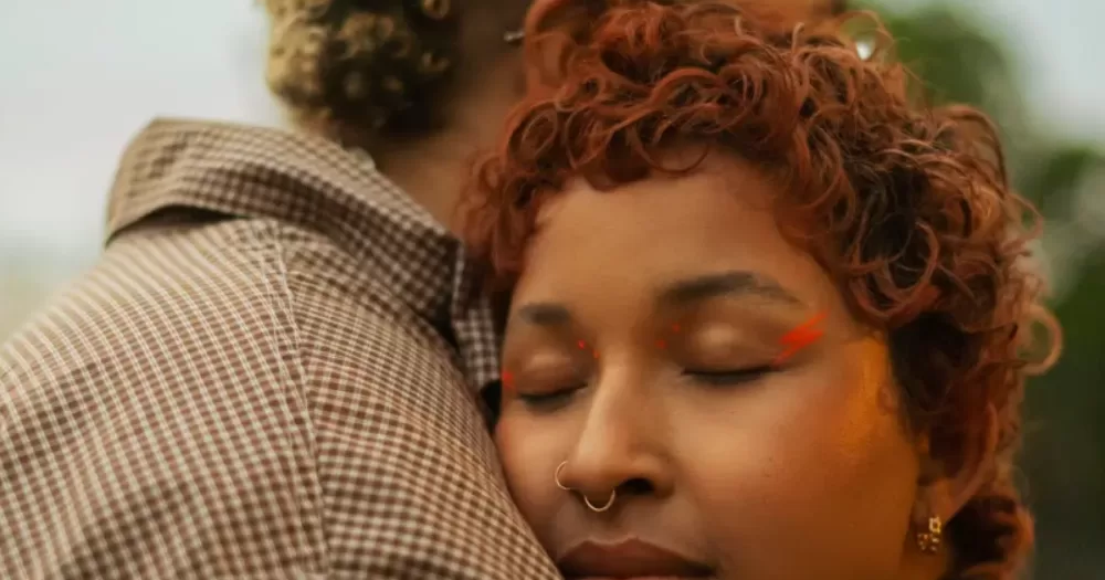 queer couple embrace one another. This article covers Valentines gift ideas