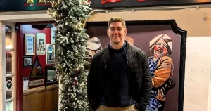 PD Savage poses in front of Christmas decorations outside a pub.