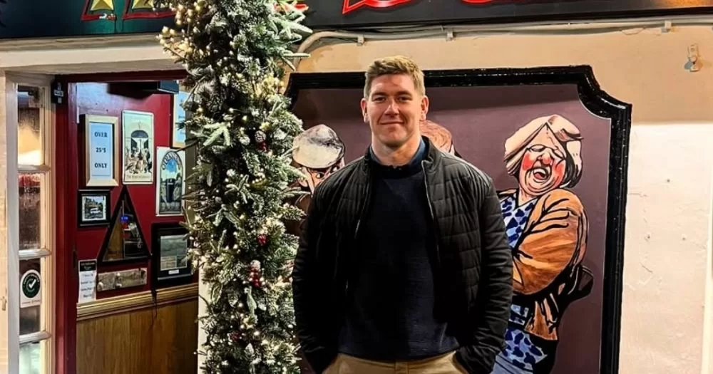 PD Savage poses in front of Christmas decorations outside a pub.