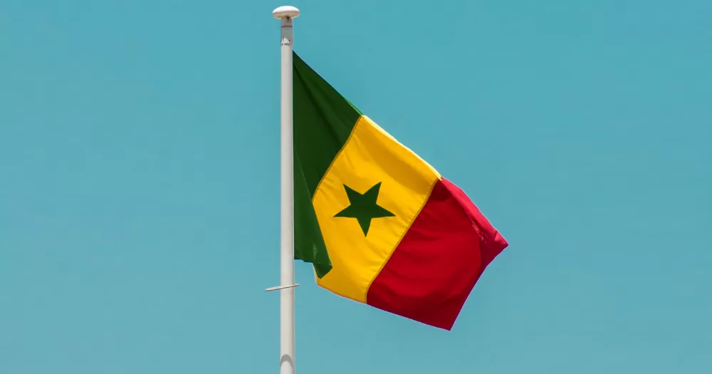 The flag of Senegal infront of a blue sky