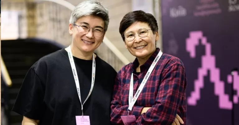 Feminist and lesbian activist Zhanar Sekerbayeva (left) stands beside another activist at a conference.