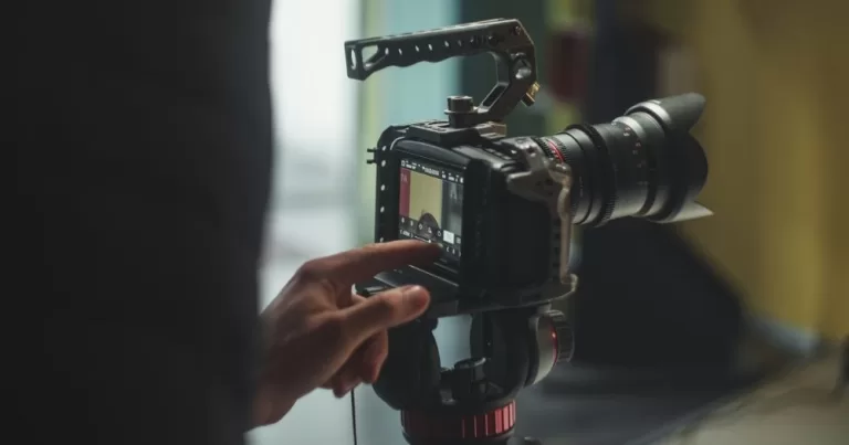 This article is about micro-shorts filmed by LGBTQ+ migrants. In the photo, a person pointing at a camera on a tripod.