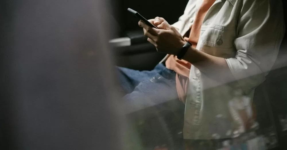 Sextortion on hook-up apps advice. A man texts on a phone.