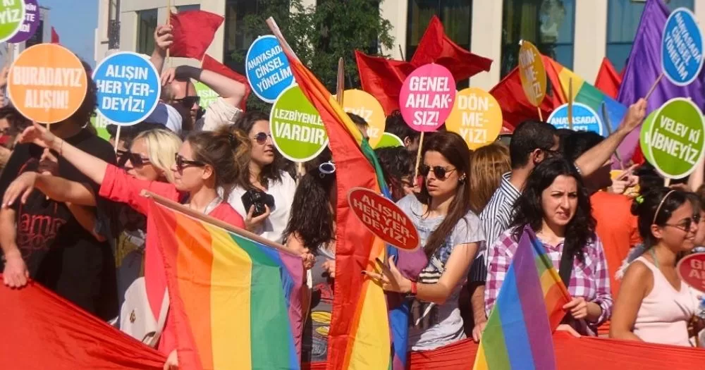 Activists in Turkey marching for LGBTQ+ rights, holding Pride flags and banners.