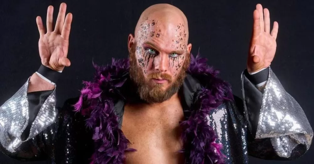 Aaron Rourke, a gay wrestler wears a purple feather boa and face make-up.