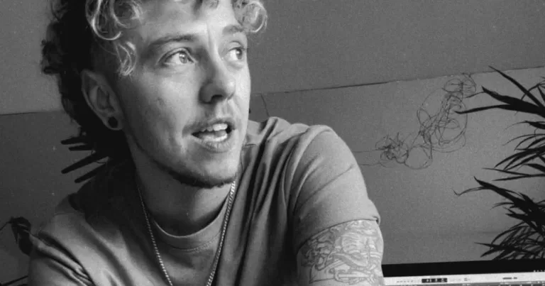 Trans musician Dylan and the Moon, who's made duets with his past self, singing in a black and white photo.