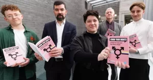 Members of rights groups holding the Know Your Rights guide for trans and non-binary people.