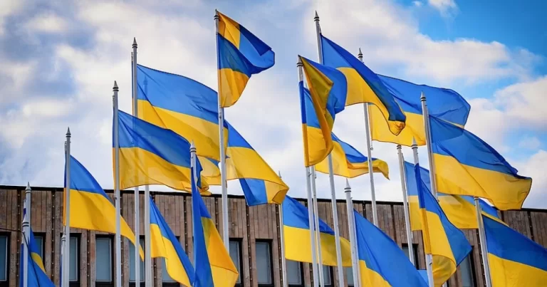 This article is about a same-sex couple in Ukraine. Flags of Ukraine flying in the sky.