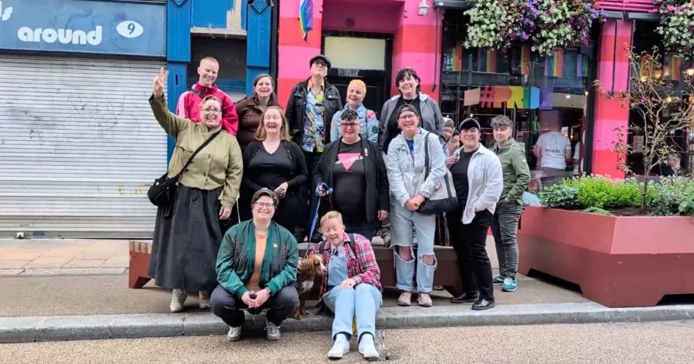 A group of people posing for a photo after taking part in the Unshrinking Violets walking tour.
