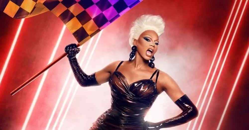 RuPaul holds up an orange, pink, and purple checkered flag in front of a smoky, red background with lasers for the All Stars 11 promo.