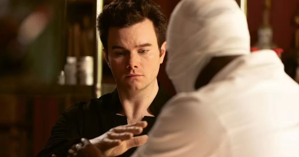 Chris Colfer in a scene of The Restoration at Grayson Manor, looking at his hand.