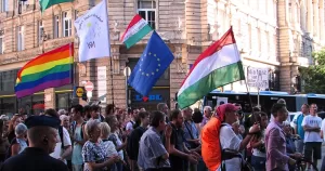 This article is about a EU court striking down Hungary's anti-LGBTQ+ law. In the photo, people marching while carrying Hungary, EU and Pride flags.