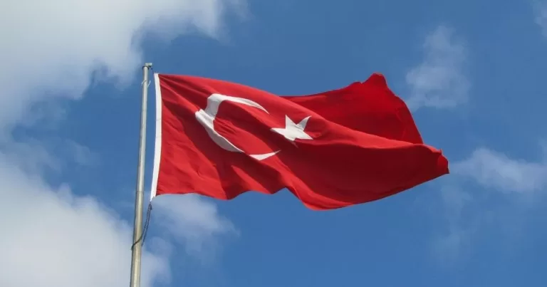 A Turkish flag against a blue sky.