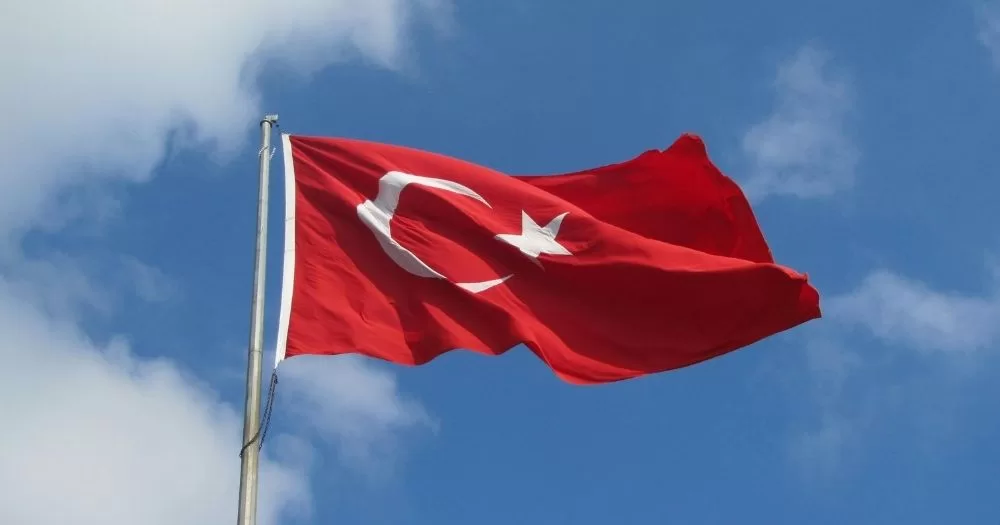 A Turkish flag against a blue sky.