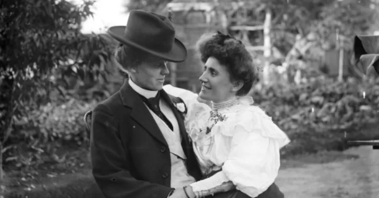 Young lesbian couple seated in garden, this article covers the history of lesbian personal ads.