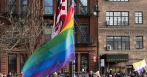 A Pride flag and the US flag flow simultaneously at the Stonewall National Monument.