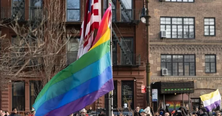 A Pride flag and the US flag flow simultaneously at the Stonewall National Monument.