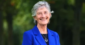 Irish President Catherine Connolly, who has become a patron of Belong To, smiling at the camera while wearing a bright blue blazer.