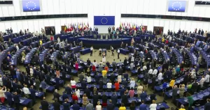 The European Parliament, which has voted in favour of a EU-wide ban on conversion therapy, with MEPs standing in front of their seats.