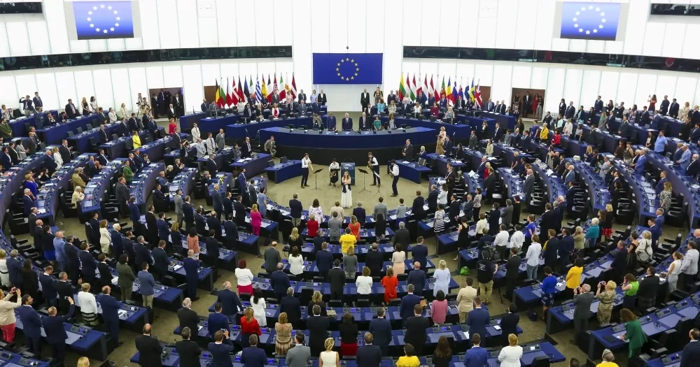 The European Parliament, which has voted in favour of a EU-wide ban on conversion therapy, with MEPs standing in front of their seats.