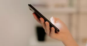A person checking a phone. This article covers a Christian mobile network.