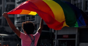 A person holding a Pride flag. This artcile covers how brands represent Pride
