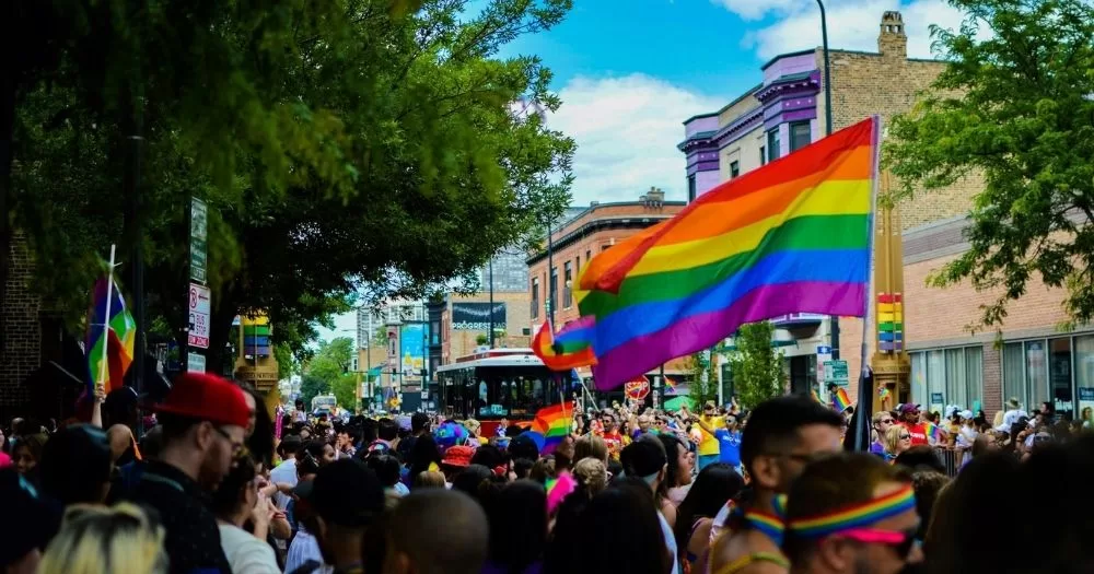 A pride march with flags in the air in solidarity.