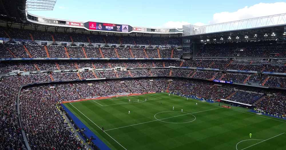 A wide angle image of Real Madrid's stadium with fans in the stands.