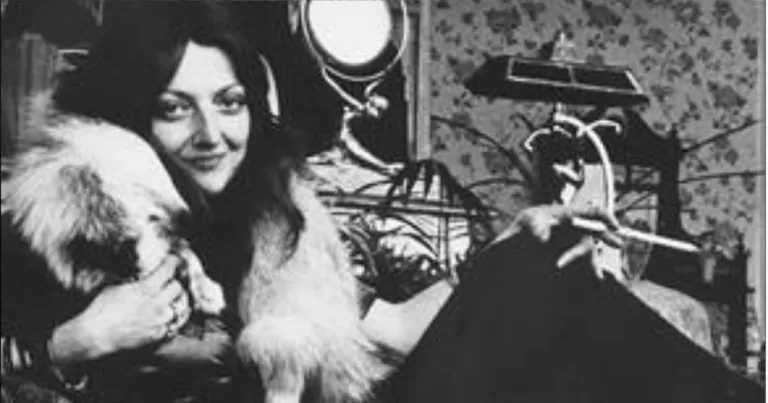 A portrait of owner of Shellys Leg, Shelly Bauman, is looking at the camera while smiling. She is wearing a fur coat and has dark hair