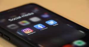 This article is about online hate speech. A phone with social media icons on the screen.