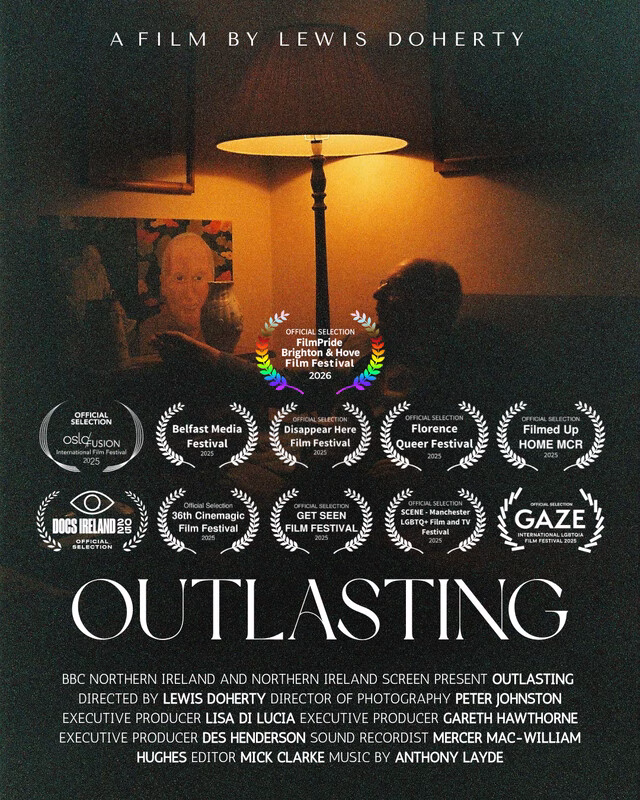 A person sits under a dim lamp, the only source of light in the room. The movie poster title reads "Outlasting", the rest of the poster is covered in award nominations and wins.