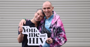 Irish HIV/AIDS activists Robbie Lawlor and Veda Lady pose for a photo, holding a sign reading "You, me and HIV".