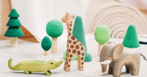 This article is about Orchard Fostering. The image shows an arrangement of children's wooden toys in the shape of trees and animals.
