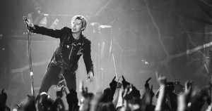 This is an article about David Bowie's unreleased songs. This is a black and white image from a David Bowie concert from 2003.