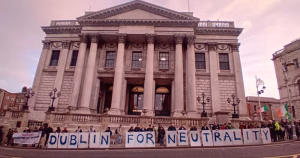 Activists standing in front of Dublin City Hall holding a banner that reads "Dublin for neutrality".