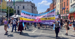 Activists marching at Trans and Intersex Pride Dublin 2026, carrying banners and flags.